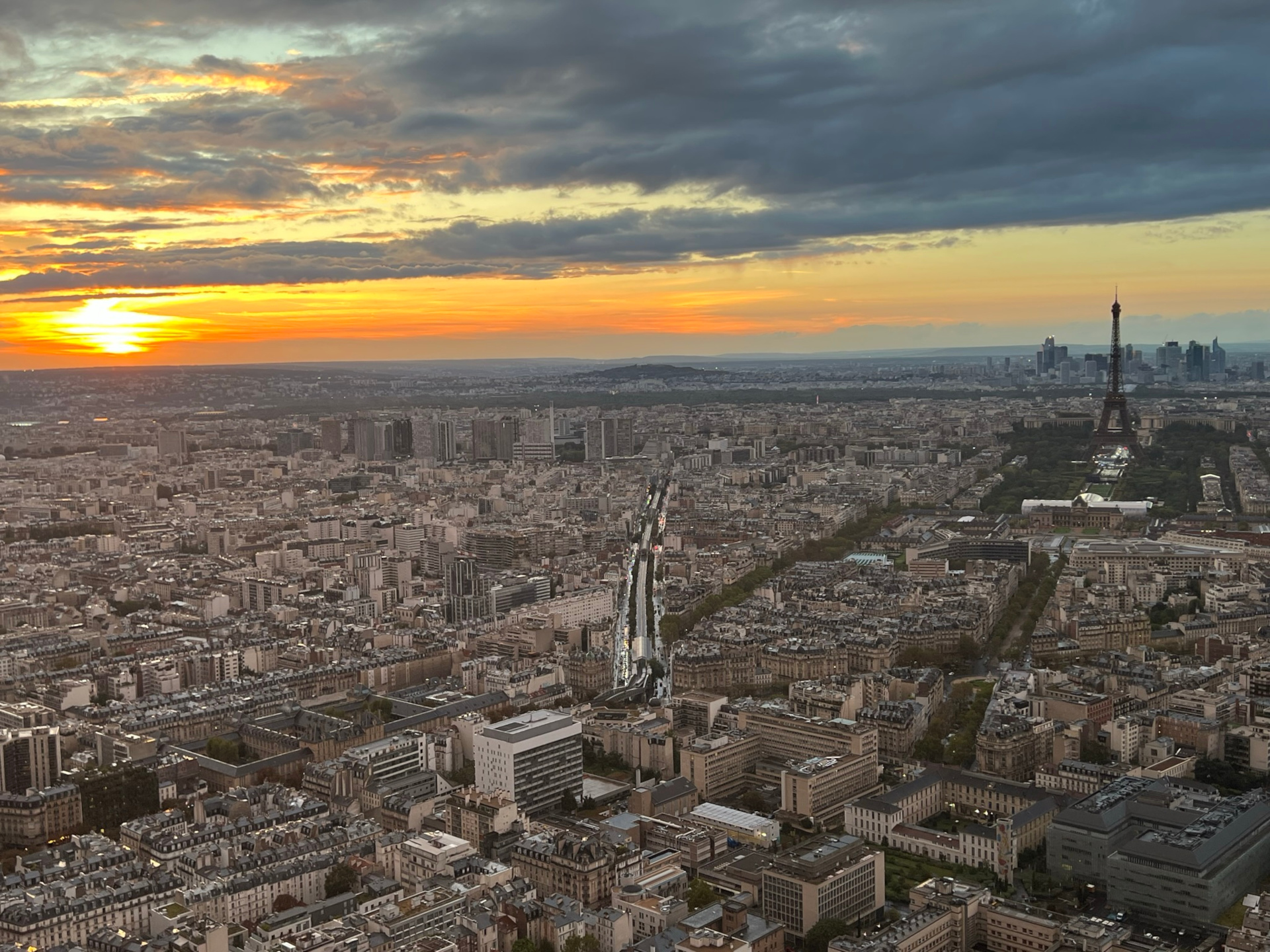 Sunset over Paris. A scattering of clouds against an evening sky over the cityscape. The Eiffel Tower is visible to the right. This photo was taken from the top of Tour Montparnasse.